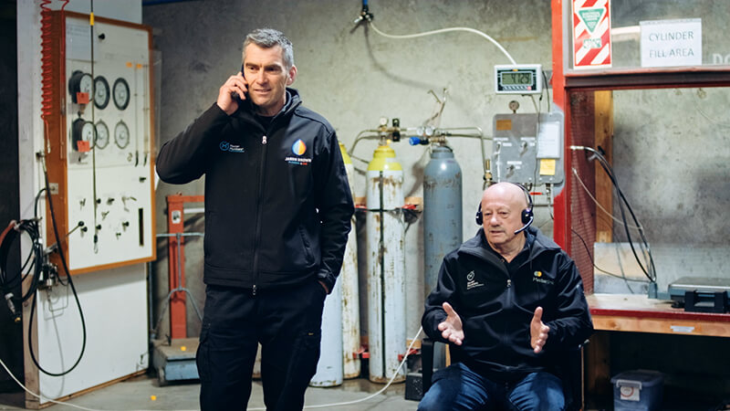Two plumbers on phone calls giving advice