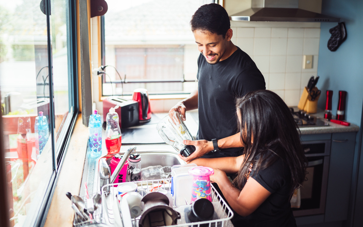 Father washing dishes with child